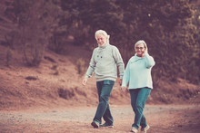 Vintage Colors Orange Tone Couple Of Caucasian Senior Man And Woman Walking Together In The Park Having Fun - Life Forever With Love And Respect - Nice Retired Lifestyle
