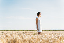 Woman Walking Trough A Golden Grass Field