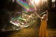© Cavan Images - 9 year old girl making giant bubble in summer light