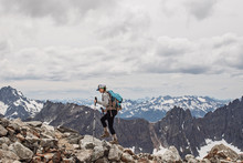 A Female Hiker Walks Amid The Snowy Peaks Of The Cascades, Washington