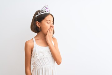 Sticker - Beautiful child girl wearing princess crown standing over isolated white background bored yawning tired covering mouth with hand. Restless and sleepiness.