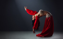 Beautiful Black-haired Girl In Red Ethnic Dress Dancing Oriental Dances Leaning Back