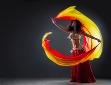 Beautiful Black-haired Girl In Red Ethnic Dress On The Stage Dances Oriental Dancing Waving Fabric In Her Hands