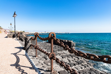 Wall Mural - Playa Blanca resort famous winding coastal promenade along Atlantic Ocean shoreline. Lanzarote, Canaries Islands, Spain.