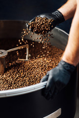 worker took Freshly roasted coffee to check the quality of mixer drum for cooling