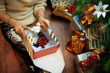 trendy woman wrapping Christmas gift joystick for him