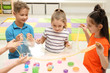 © New Africa - Happy children playing with slime at table indoors