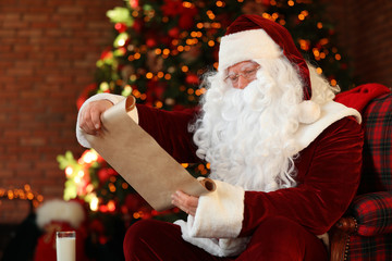 Poster - Santa Claus with wish list near Christmas tree indoors