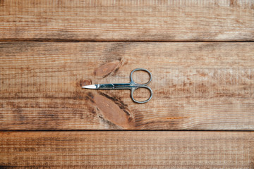 Canvas Print - Scissors for cutting nails on a wooden table. The concept of doing makeup, caring for the appearance of women. Applying brushes, eye shadows, powder.