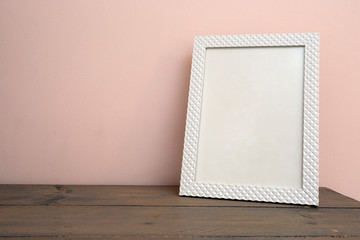 Wall Mural - White blank mock up of photo frame on the light background. Home interior, wooden shelf near pink wall