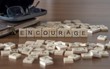 encourage the word or concept represented by wooden letter tiles