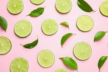Juicy Fresh Lime Slices And Green Leaves On Pink Background, Flat Lay