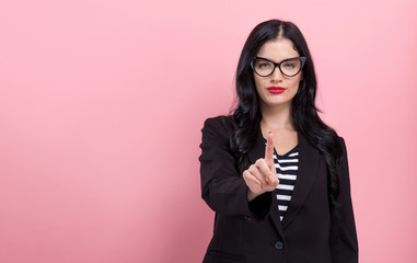 Wall Mural - Young woman pointing at something on a pink background