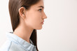 © Pixel-Shot - Young woman with hearing aid on light background