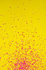 Wall Mural - Falling confetti on yellow background. Holiday and party concept.