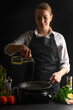© Anton - Chef pouring oil on a frying pan, freezing in motion. On a background with ingredients. Homemade fish recipes, gastronomy