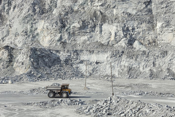 Wall Mural - Dump truck loaded with rock ore against the backdrop of a huge quarry.