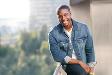 Relaxed And Casual Modern African American Male Portrait In Blue Jean Jacket On A City Rooftop During Sunset