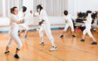 © JackF - Young woman fencer practicing effective fencing techniques in training room