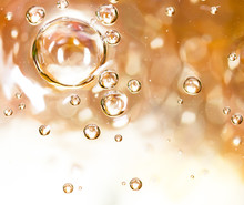 Bubbles Of Air On The Smooth Surface Of Golden Water As An Abstract Background