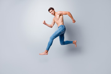 Poster - Full size profile photo of focused macho man guy jumping high running topless torso metrosexual hot body competitive mood wear only jeans isolated grey background