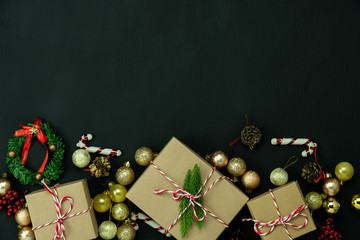 Wall Mural - Table top view of Merry Christmas decorations & Happy new year ornaments concept.Flat lay essential difference objects gift box & fir tree on modern black paper background at home studio office desk.