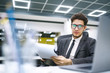 © maxbelchenko - Young office worker in glasses reads documents in the modern office. Young business manager working with new startup project. Stylish man in a suit reviews and analyze documents, plans.