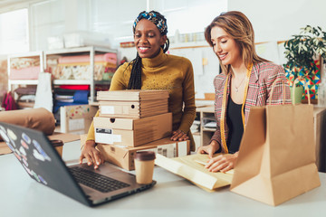 Wall Mural - Sales Online. Working women at their store. They accepting new orders online and packing merchandise for customer.