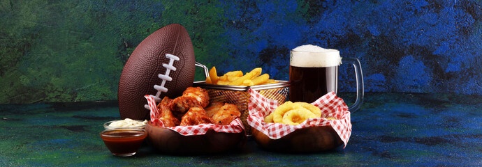 chicken wings, fries and onion rings for football on a table. Great for Bowl Game party