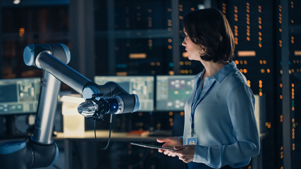 Leinwandbilder - Female Engineer with Tablet Computer Analyse How a Futuristic Robotic Arm Works and Moves a Metal Object. High Tech Research Laboratory with Modern Equipment.
