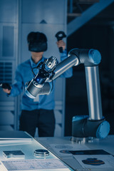 Leinwandbilder - Vertical Shot of Professional Development Engineer in Blue Shirt Controlling Futuristic Robotic Arm with Virtual Reality Headset and Joysticks in a High Tech Research Laboratory with Modern Equipment
