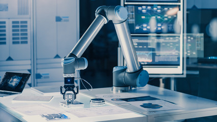 Leinwandbilder - Futuristic Artificial Intelligence Robotic Arm Operates and Moves a Metal Object, Picks It Up and Puts it Down. Scene is Taken in a High Tech Research Laboratory with Modern Equipment.