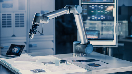 Poster - Futuristic Artificial Intelligence Robotic Arm Operates and Moves a Metal Object, Picks It Up and Puts it Down. Scene is Taken in a High Tech Research Laboratory with Modern Equipment.