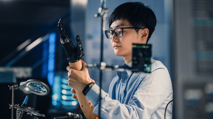 Leinwandbilder - Futuristic Prosthetic Robot Arm Being Tested by a Professional Japanese Development Engineer in a High Tech Research Laboratory with Modern Computer Equipment. He is Satidfied with the Result.