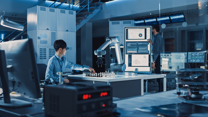 Leinwandbilder - Professional Japanese Development Engineer is Testing an Artificial Intelligence Interface by Playing Chess with a Futuristic Robotic Arm. They are in a High Tech Modern Research Laboratory.
