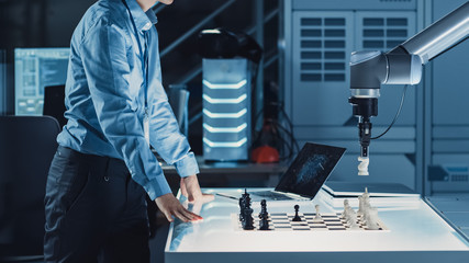 Poster - Professional Japanese Development Engineer is Testing an Artificial Intelligence Interface by Playing Chess with a Futuristic Robotic Arm. They are in a High Tech Modern Research Laboratory.
