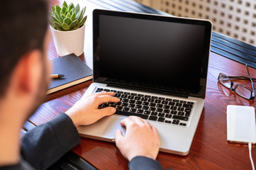 Wall Mural - Laptop with black blank screen on a wooden desk