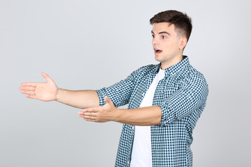 Canvas Print - Young disappointed man on grey background