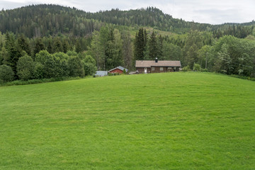 house at the top of meadow in green countryside, near Honefoss, Norway