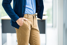 Close Up Fashion Image Of Wrist In A Business Suit Of Man Detail Of A Businessman,Man's Hand In Brown Or Gold Pants Pocket And Wearing Blue Jacket And Blue Shirt In The Office Room Background.