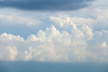 Wall Mural - Background of white cumulus clouds on a blue sky at daylight. Telephoto zoom shoot