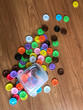Button beads are blue, green, yellow, pink, white, purple, background. Pour  on the table to the right
