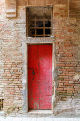 Wall Mural - Old weathered red door in a building