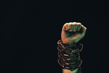 Fototapete - Human hand are chained in chains isolated on black background.