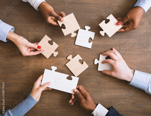 Fotomural Group of business people assembling jigsaw puzzle together
