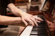 © Мар'ян Філь - Hands of a young teenage boy playing a familiar melody on the keys of a brown piano