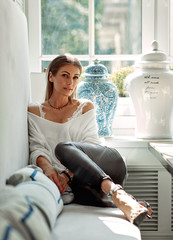 Relaxing woman sitting comfortable in sofa lounge chair smiling happy looking at camera