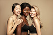 © Beauty Agent Studio - Beauty. Multi Ethnic Group of Womans with diffrent types of skin  together and looking on camera. Diverse ethnicity women - Caucasian, African and Asian posing and smiling against beige background.