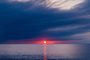 Wall Mural - Beautiful sunset in blue clouds on the seashore