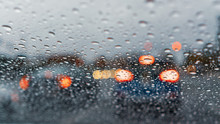 Raindrops On The Windshield On A Rainy Day; Cars Stopped At A Traffic Light In The Background; California